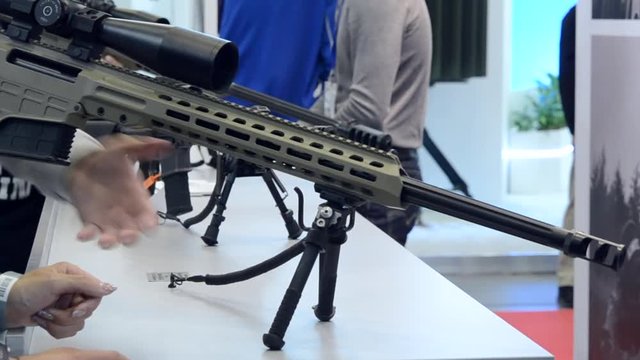 Several large-caliber weapons on the table. Firearms gun submachine sniper rifle close-up.