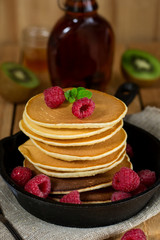 Pancakes hotcakes with berries and fruit served with maple syrup