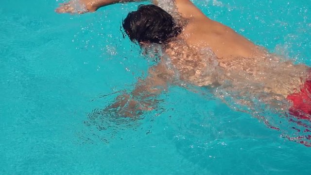 slow motion of professional swimmer swimming the crawl in outdoor pool