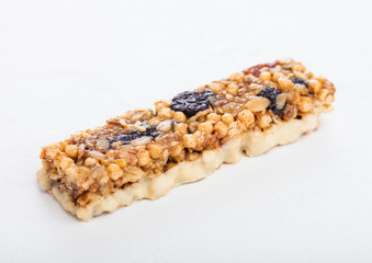 Homemade organic granola cereal bar with nuts and dried fruit on white background