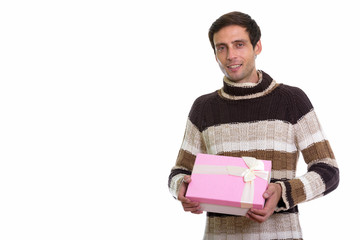 Studio shot of happy young handsome man smiling while holding gi