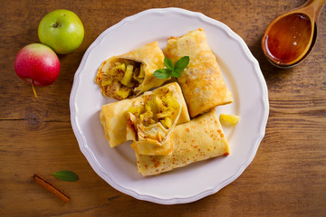Delicious homemade crepes filled with apples and cinnamon. overhead, horizontal