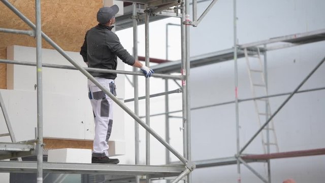 Caucasian Construction Worker Looking Around From a Scaffolding