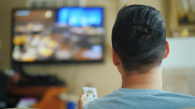 Asian Man Watching Television, Rear View.