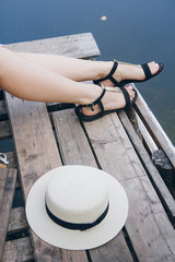 Girl in a hat resting on the autumn lake on the bridge