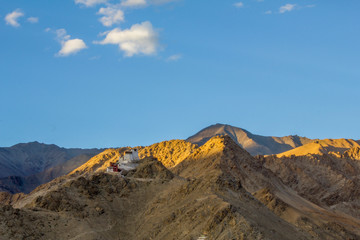 Fototapeta na wymiar rays of the setting sun over the Tibetan temple in the mountains