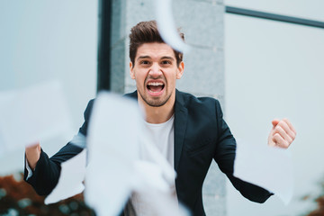 Angry furious male office worker throwing crumpled paper, having nervous breakdown at work,...
