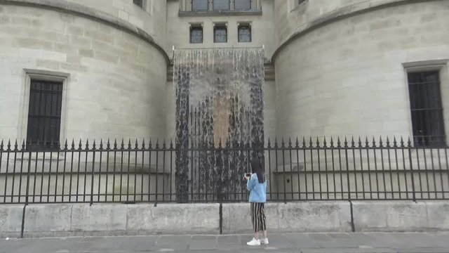 A girl taking photos of a fountain of Conciergerie palace, Paris, France