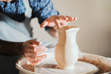 Potter creates jug nose, works on details and functionality of the product. Male artist operates hands, which gently creating correctly shaped handmade from clay