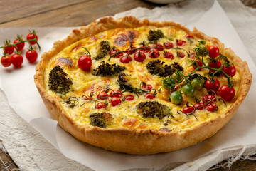 Whole quiche pie on rustic table