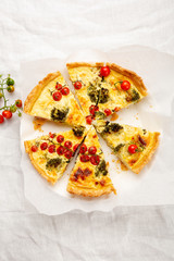 Sliced quiche pie top view on white