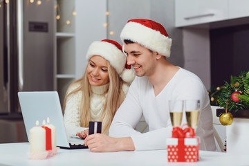 A couple shopping on the internet at home for Christmas.
