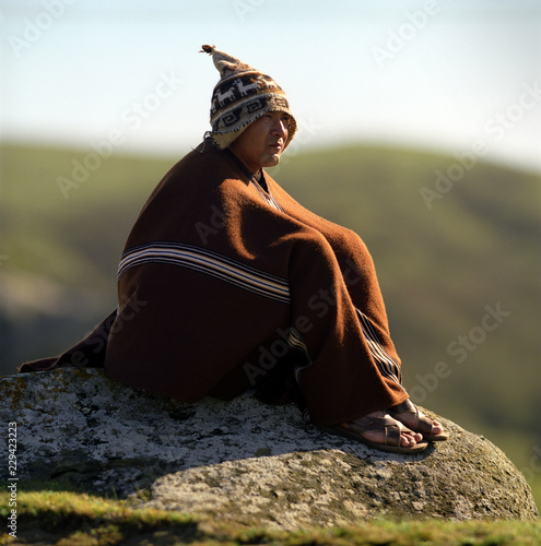 "A thoughtful young man sitting on a rock." Stock photo and royalty