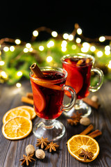 Cups of mulled wine with cinnamon and citrus pieces