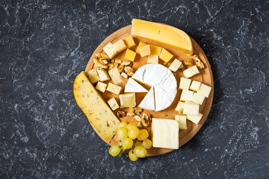 various types of cheese on dark stone table