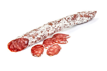 Traditional Spanish Fuet thin dried sausage with slices, Close-up, isolated on a white background.