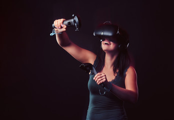 Beautiful young woman with virtual reality headset and joysticks playing video games. © Fxquadro