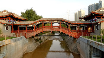 Fototapeta na wymiar China. An old bridge over the river