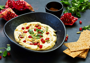 Traditional hummus, with pomegranate and cereal loaves. selective focus.