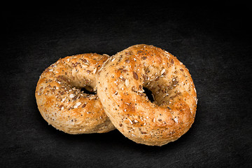 Fresh multi-grain bagel bread, isolated on a natural slate stone in background.