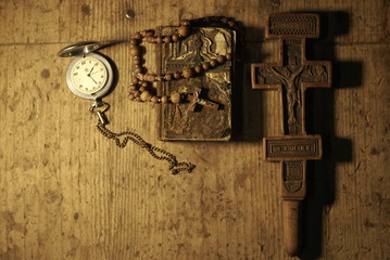 old prayer book rosary old wooden cross and old clock on a wooden table