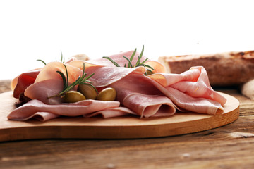 Sliced ham on wooden background. Fresh prosciutto. Pork ham sliced.