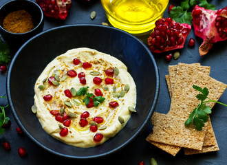 Traditional hummus, with pomegranate and cereal loaves. selective focus.