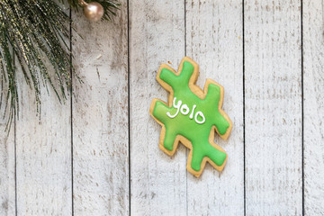 Homemade decorated sugar cookie in a hashtag shape with the phrase YOLO (you only live once) written on the cookie. Isolated on whitewashed wooden background