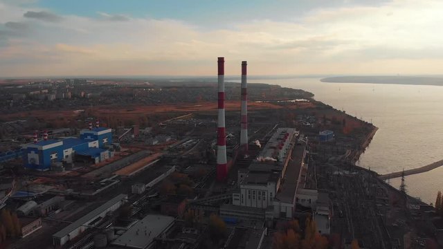 Aerial view of Voronezh Power Plant or station with high chimneys near water reservoir at sunset, drone footage