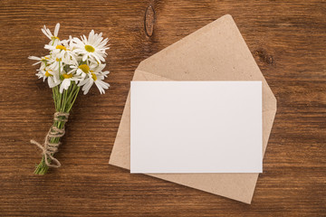  Envelope and flowers daisy on a wooden background   	