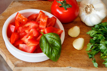 Chopped tomato on wooden board with parlsey,basil and garlic
