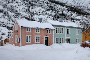 Small wooden houses by the river banks of Vefsna  in Mosj&oslash;en city, Northern Norway, House in snow