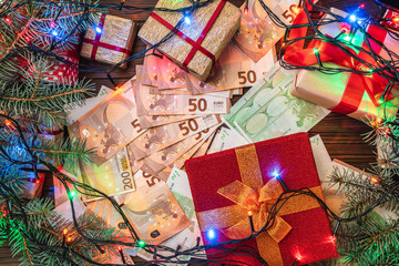 Fototapeta na wymiar Christmas background. Gifts for loved ones. Money of different values. The atmosphere of Xmas. Top view.