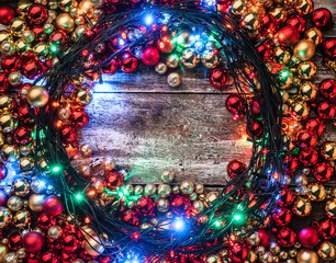Fototapeta na wymiar Christmas background with red and gold baubles, lighted around, in the center of space for your message. Top view. Xmas congratulations.