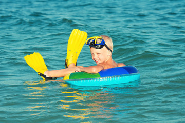 Boy in masks and fins swims in the sea Small diver.