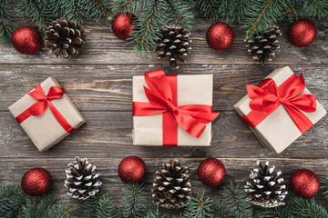 Old wood background with fir branches adorned with baubles and cones. Space for text. Christmas card. Top view. Xmas gifts.