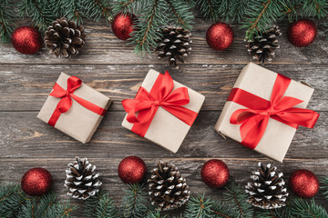 Old wood background with fir branches adorned with baubles and cones. Space for text. Christmas card. Top view. Xmas gifts.