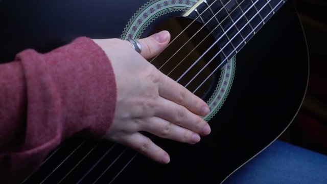 Girl playing guitar in slow motion.