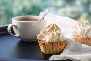 Cream cupcakes and a cup of tea.