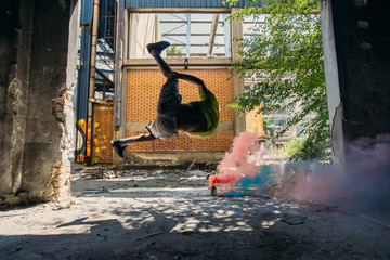 Free runner exercising around colorful smoke bomb