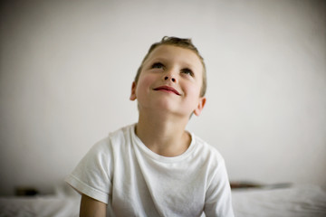 Smiling young boy looking upwards.