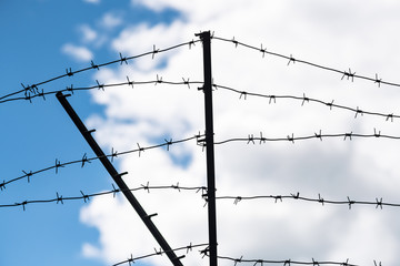 Barbed wire on country border. Barbwire on fence for prohibition of illegal aliens crossing.