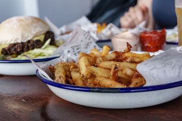 closeup of rosemary french fries in front of vegan black beans burger on a plate