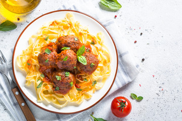 Meatballs in tomato sauce with pasta tagliatelle top view.