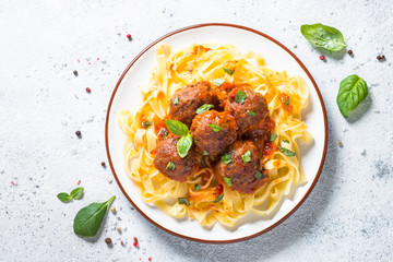 Meatballs in tomato sauce with pasta tagliatelle top view.