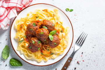 Meatballs in tomato sauce with pasta tagliatelle top view.