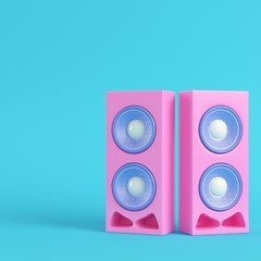 Pink stereo speakers on bright blue background in pastel colors