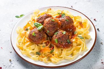 Meatballs in tomato sauce with pasta tagliatelle.