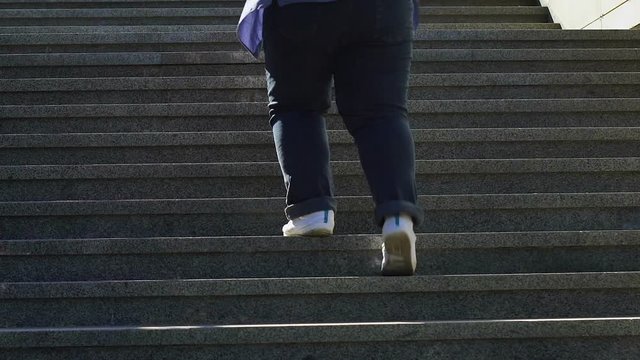 Overweight man climbing stairs, suffering dyspnea, problems with health, obesity