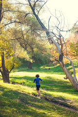 The girl runs through the autumn park.